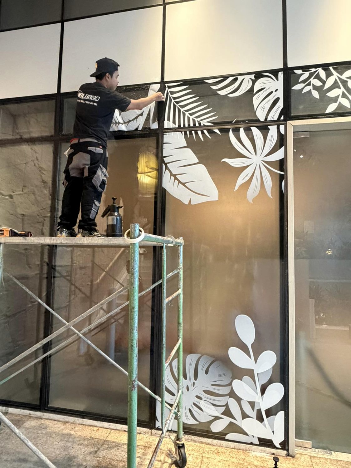 Installer registering the leaf artwork across mullion joints