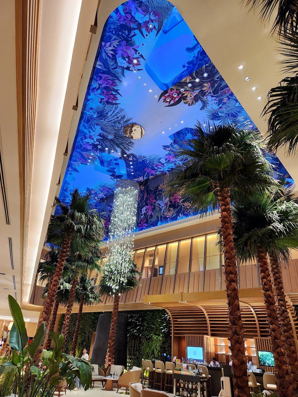 Swissotel lobby atrium: tropical ceiling artwork and skylight over the palms