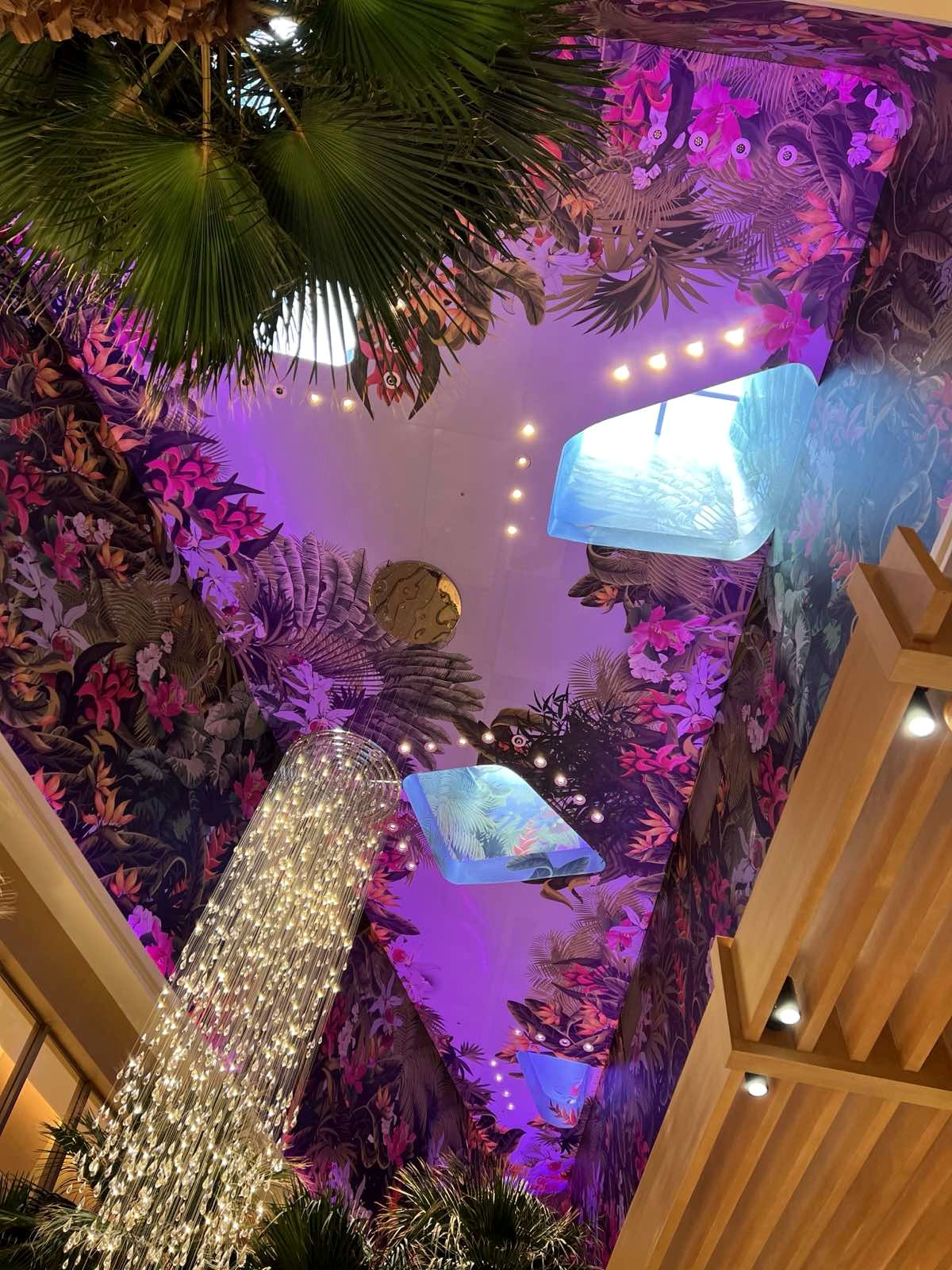 Ceiling artwork detail with skylight panels and chandelier
